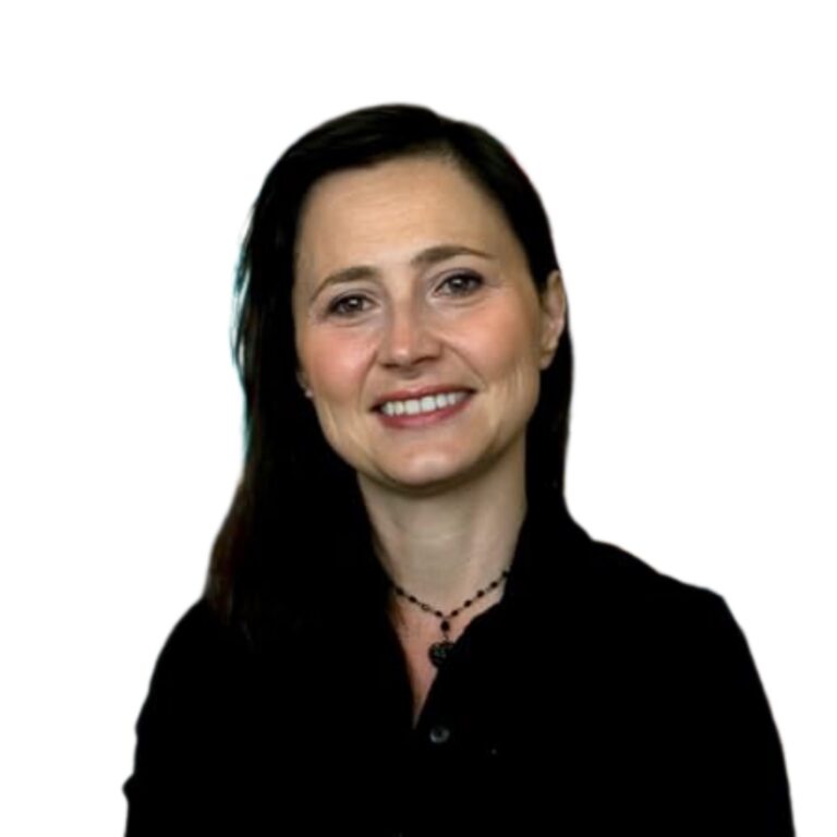 A woman with dark hair, wearing a black top and a beaded necklace, smiles at the camera. The background is plain white.